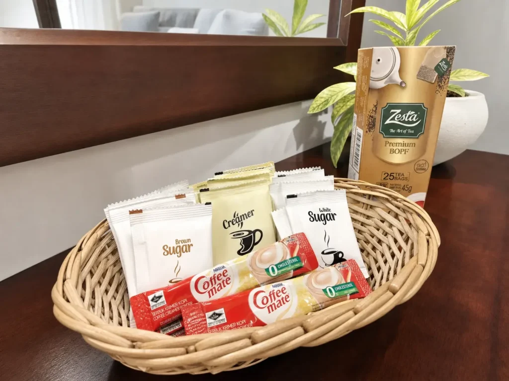 A selection of tea sachets and coffee beside a mirror