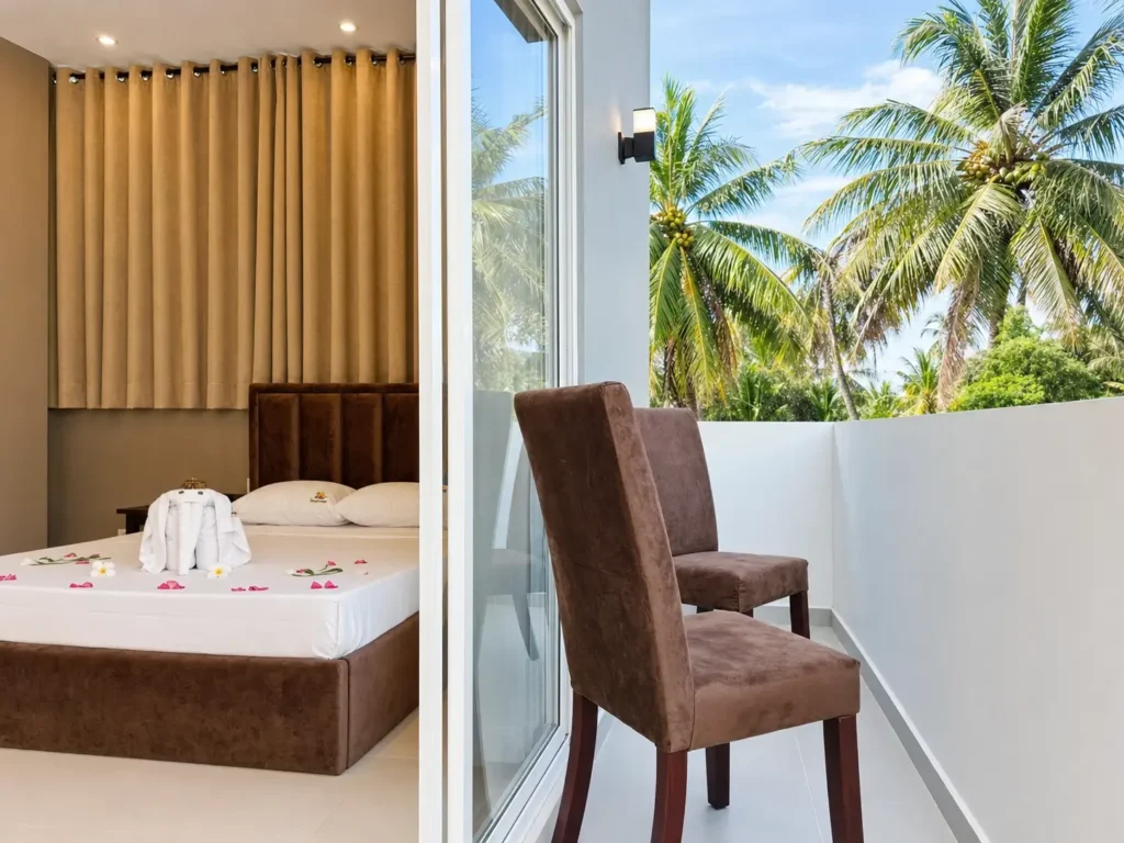 Private balcony of the triple room, with chairs and palm trees beyond